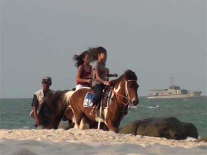 Girls on horseback riding along Hua Hin beach